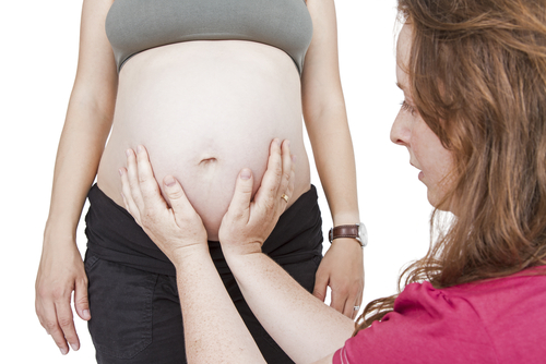 midwife touching pregnant belly