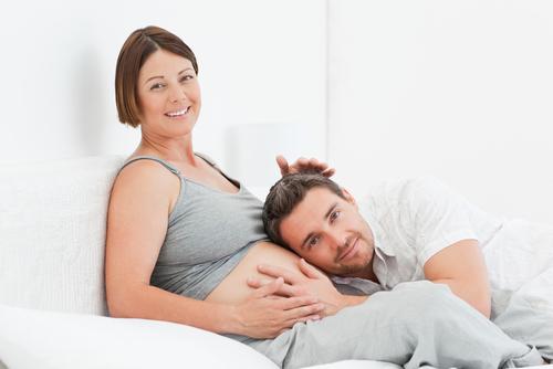 Pregnant couple in bed