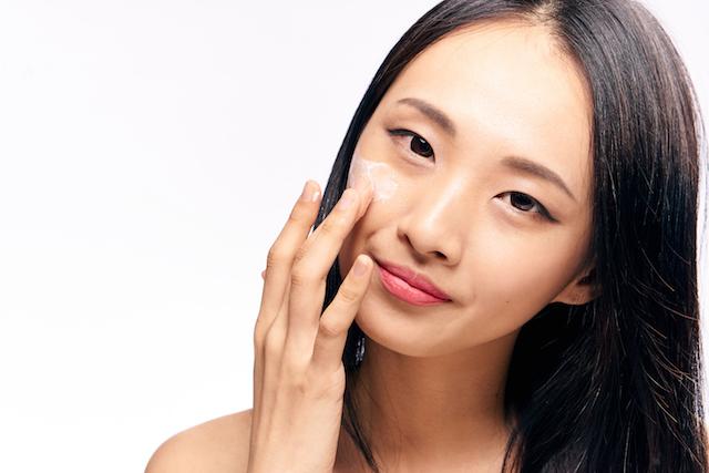 woman asian applying face cream
