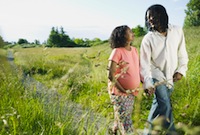 Pregnant couple walks in a field